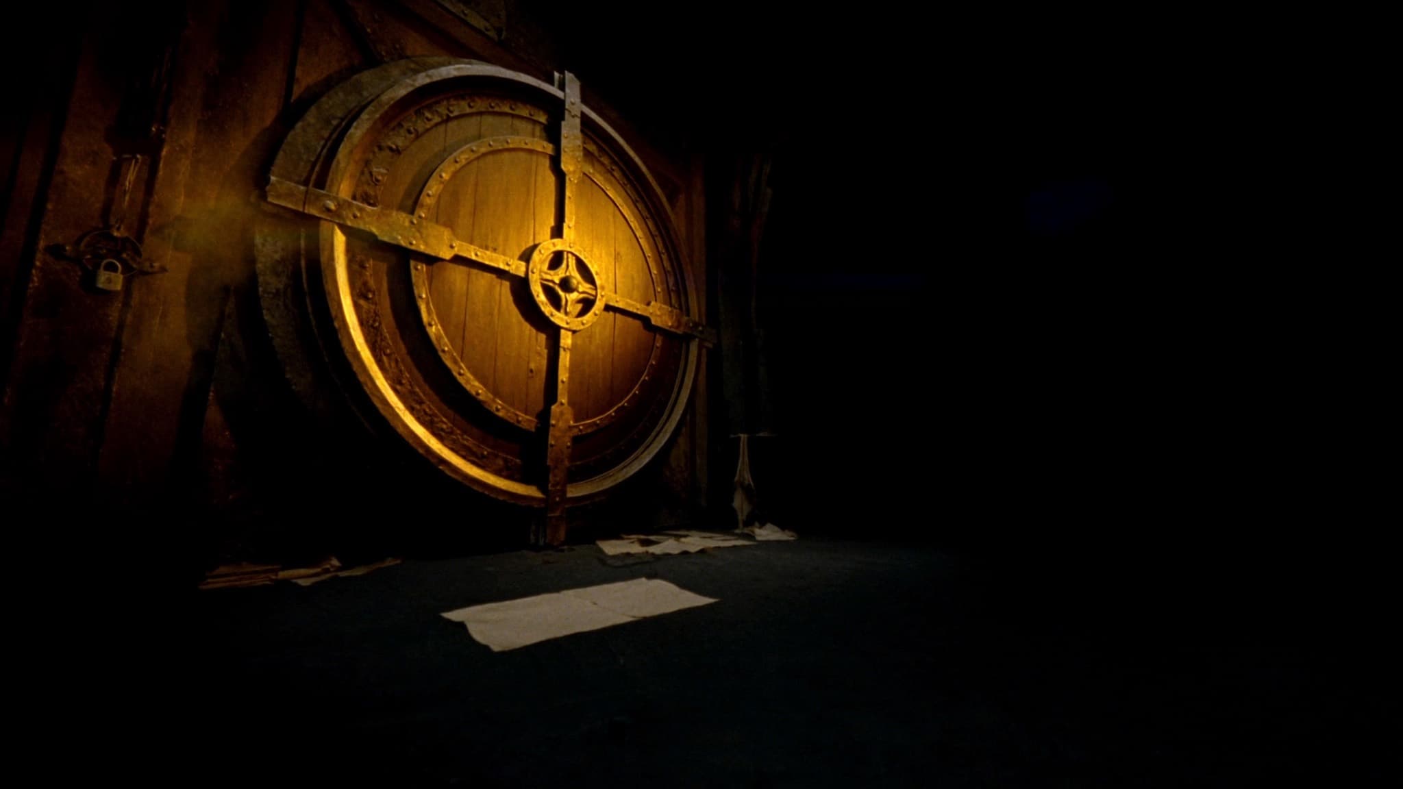 Enorme puerta de bóveda antigua de hierro y madera con un mecanismo circular